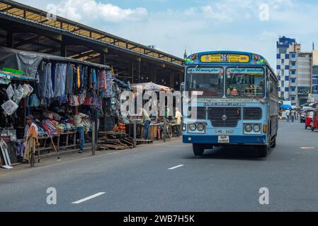 COLOMBO, SRI LANKA - 23. FEBRUAR 2020: Ein Stadtbus fährt an einem Straßenmarkt vorbei Stockfoto