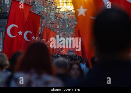 Türkische Fahnen und überfüllte Menschen in der Istiklal Avenue bei Sonnenuntergang. Nationalfeiertage von Turkiye Konzeptfoto. Istanbul Turkiye - 10.28.2023 Stockfoto