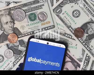 Deutschland. Januar 2024. In dieser Fotoabbildung ist ein Global Payments Logo auf einem Smartphone mit US-Dollar-Banknoten und -Münzen im Hintergrund zu sehen. Quelle: SOPA Images Limited/Alamy Live News Stockfoto