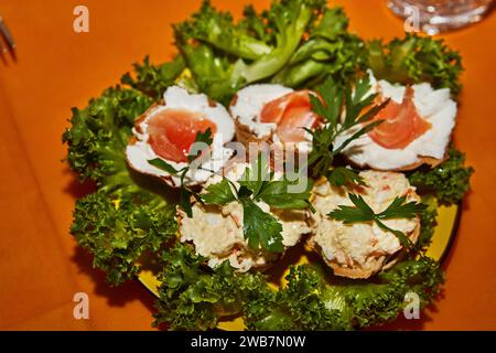 Wunderschön gestaltete festliche Silvestertisch mit Käsekörben, frischem Lachs und lebendigem Grün, die eine elegante und einladende Atmosphäre schaffen Stockfoto