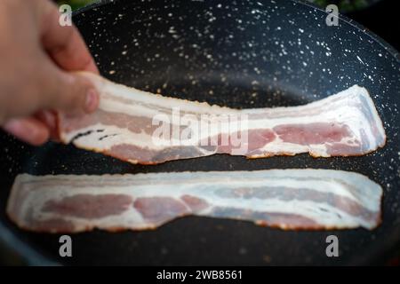 Drei Speckscheiben in der Pfanne braten. Stockfoto