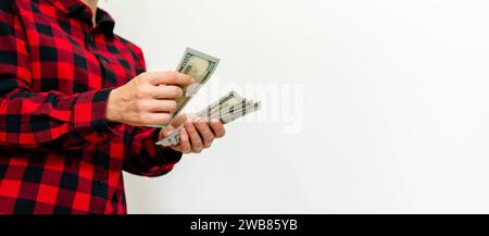 Eine Frau zählt US-Dollar-Scheine in ihren Händen. Finanzielles Wohlergehen Stockfoto