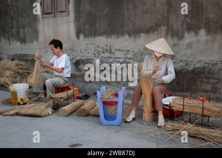 Mann und Frau machen Räucherstäbchen im Quang Phu Cau Räucherdorf in Hanoi, Vietnam Stockfoto