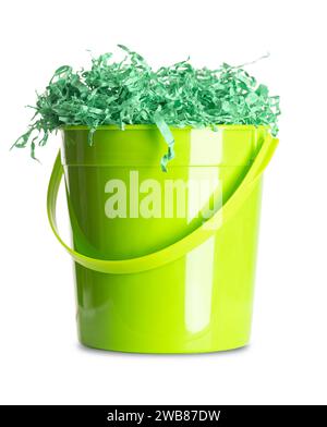 Papier-Ostergras in einem grünen Plastikeimer. Farbenfrohe und zerknitterte Geschenkkörbe zum Füllen und Dekorieren, gefüllt in den Eimer. Stockfoto