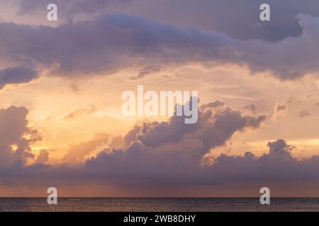 Farbenfrohe Wolken des tropischen Himmels über dem Ozean bei Sonnenuntergang, natürliches Hintergrundfoto Stockfoto