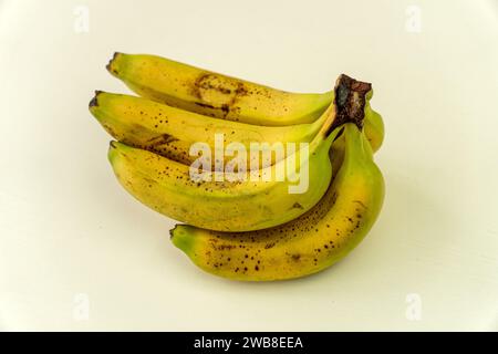 Reife gelbe Bananenfrüchte, ein Haufen reifer Bananen mit dunklen Flecken auf weißem Hintergrund Stockfoto