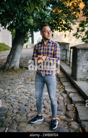 Junger Geschäftsmann in Hemd, der in einer historischen Straße steht Stockfoto