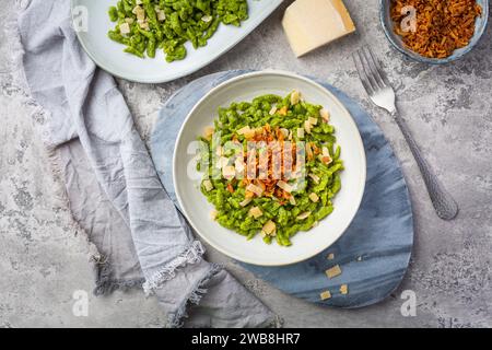 Spinatspätzle mit Parmesan und gerösteten Zwiebeln - Deutsche Eiernudeln Stockfoto