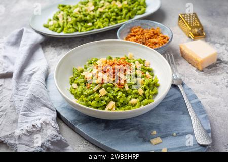 Spinatspätzle mit Parmesan und gerösteten Zwiebeln - Deutsche Eiernudeln Stockfoto