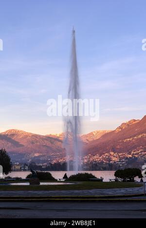 Der Wasserstrahl am Paradiso auf der Seite des Lugano-Sees bei Sonnenuntergang mit Monte Bre am Nachmittag glühender Hintergrund Stockfoto