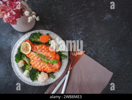 Lachssteak mit Gemüse Blumenkohl, Brokkoli, Karotten und grünen Bohnen. Salat aus Rucola und Gemüse mit Lachs. Draufsicht, flach Stockfoto