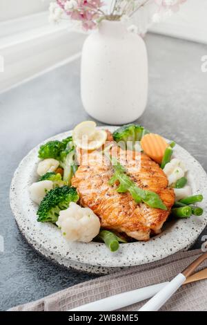 Lachssteak mit Gemüse Blumenkohl, Brokkoli, Karotten und grünen Bohnen. Salat aus Rucola und Gemüse mit Lachs. Stockfoto