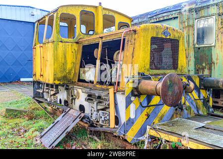 Seitenwinkelansicht der gelb zerlegten und baufälligen alten Zugkontrollkabine auf stillgelegten Gleisen am alten Bahnhof, Kupplungsstopps, rostige und korrodierte Meta Stockfoto