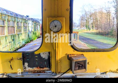 Alte Personenwagen durch Fenster auf verschwommenem Hintergrund gesehen, abgebaute Eisenbahnkabine, Metall korrodiert und rostet im Laufe der Zeit, stillgelegte Trai Stockfoto