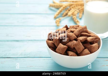 Schokoladenpolster Kornflocken in der Schüssel auf blauem Hintergrund. Getreidestruktur. Draufsicht Stockfoto
