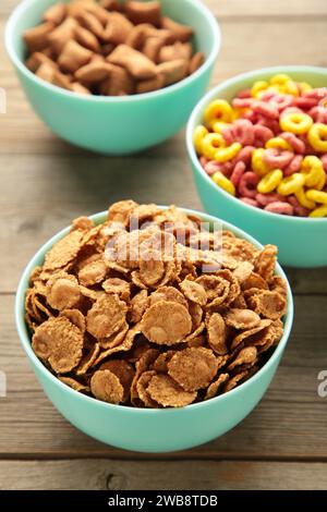 Auswahl an Müsli in blauen Schüsseln, schnelles Frühstück auf grauem Holzhintergrund. Draufsicht Stockfoto