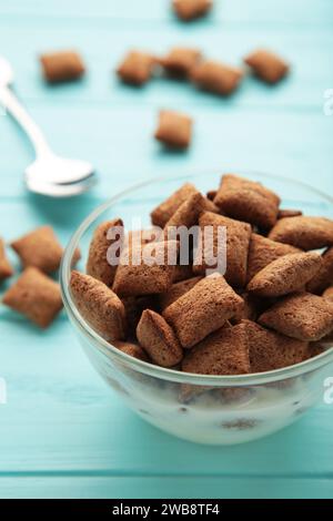 Schüssel mit Schokoladenpads auf blauem Hintergrund. Draufsicht Stockfoto