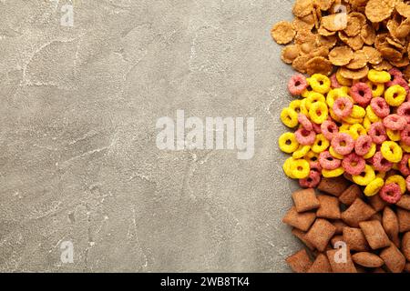 Auswahl an Müsli und Cornflakes auf grauem Hintergrund, schnelles Frühstückskonzept. Draufsicht Stockfoto