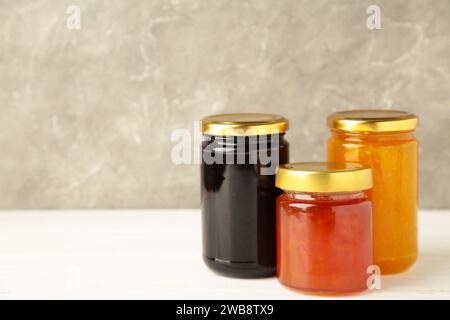 Auswahl an Marmeladen, frischen Beeren der Saison und Früchten auf weißem Hintergrund. Draufsicht Stockfoto