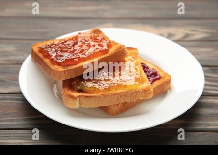 Frischer Toast mit Butter und verschiedenen Marmeladen auf dem Tisch. Draufsicht Stockfoto