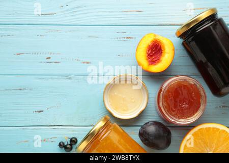 Auswahl an Marmeladen, frischen Beeren der Saison und Früchten auf blauem Hintergrund. Draufsicht Stockfoto