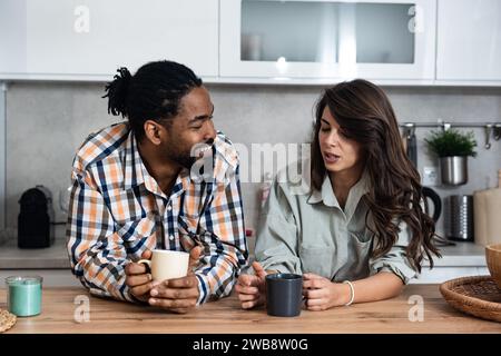 Geschäftskollegen sprechen während der Mittagspause in der Büroküche. Frau kommuniziert mit Arbeitskollegen Kaffeetassen halten Unterhaltung genießen, Arbeit besprechen oder p Stockfoto