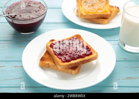 Süße Toasts mit Marmelade zum Frühstück auf Blau. Draufsicht Stockfoto
