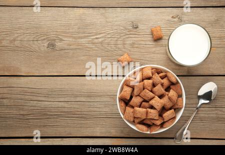 Schokoladenpolster Kornflocken in der Schüssel auf blauem Hintergrund. Getreidestruktur. Draufsicht Stockfoto