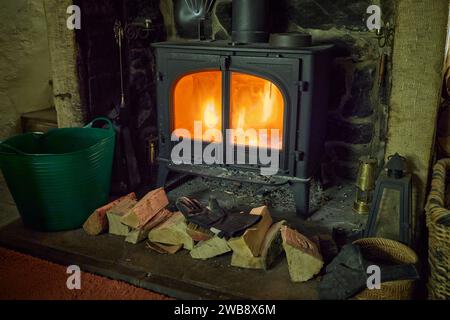 In einer häuslichen Situation heizt ein Holzofen den Wohnbereich eines traditionellen Kleinbetriebs in North Yorkshire. UK Stockfoto
