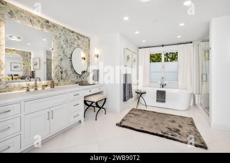 Das moderne Badezimmer verfügt über zwei moderne Waschbecken und eine einladende Badewanne Stockfoto