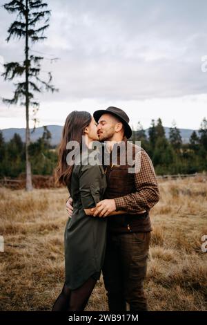 Das junge, reizende Paar, der Jäger und seine Dame küssen und umarmen sich in der Natur Stockfoto