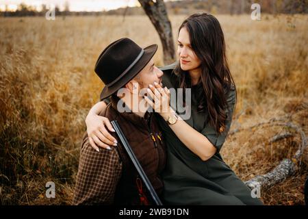 Das junge, reizende Paar, der Jäger und seine Dame, die sich gegenseitig halten, draußen in der Natur Stockfoto