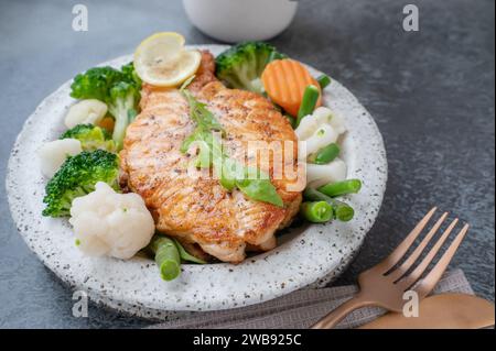 Lachssteak mit Gemüse Blumenkohl, Brokkoli, Karotten und grünen Bohnen. Salat aus Rucola und Gemüse mit Lachs. Kopierbereich Stockfoto