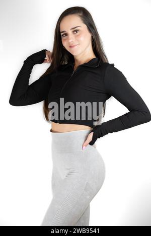 Eine junge Frau posiert selbstbewusst in stilvoller Freizeitkleidung Stockfoto