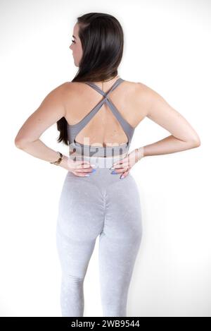 Eine junge Frau mit einer schlanken Figur, die schwarze Leggings trägt, wird mit dem Rücken zur Kamera stehend gesehen Stockfoto