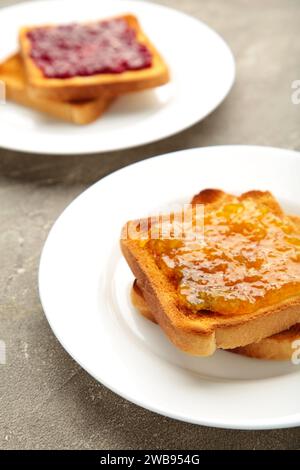 Frischer Toast mit Butter und verschiedenen Marmeladen auf dem Tisch. Draufsicht Stockfoto