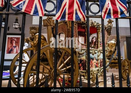 London, Großbritannien. Januar 2024. Eine Nachbildung des Gold State Coach. Schätzung: £ 30.000-50.000, gesehen durch die Nachbildung der berühmten schmiedeeisernen Tore des Buckingham Palace, mit einer Schätzung von £ 6.000-8.000 - Eine Vorschau auf die Crown Auction in der Bonhams New Bond Street, London. Mehr als 450 Kostüme, Sets und Requisiten aus der preisgekrönten Serie The Crown, einer Netflix-Show. Sie werden vom 11. Januar bis zum 5. Februar vor der Auktion am Mittwoch, den 7. Februar, kostenlos für die Öffentlichkeit ausgestellt. Guy Bell/Alamy Live News Stockfoto