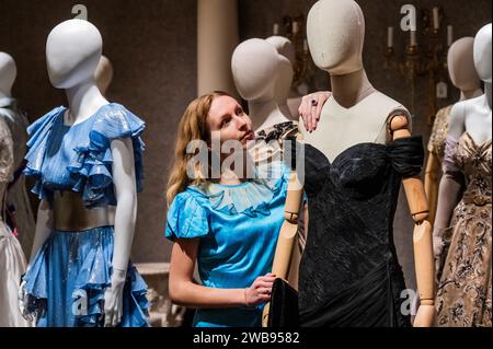 London, Großbritannien. Januar 2024. Das „Revenge Dress“, ein maßgeschneidertes schwarzes Off-the-Shoulder Cocktailkleid. Getragen von Elizabeth Debicki (als Prinzessin Diana) in Staffel 5 Folge 5. Schätzung: £8.000-12.000, getragen von Emma Corrin (als Lady Diana Spencer) Staffel 4 Folge 3, Schätzung: £2.000-3.000 – Eine Vorschau der Crown Auction in der Bonhams New Bond Street, London. Mehr als 450 Kostüme, Sets und Requisiten aus der preisgekrönten Serie The Crown, einer Netflix-Show. Sie werden vom 11. Januar bis zum 5. Februar vor der Auktion am Mittwoch, den 7. Februar, kostenlos für die Öffentlichkeit ausgestellt. Guy Stockfoto