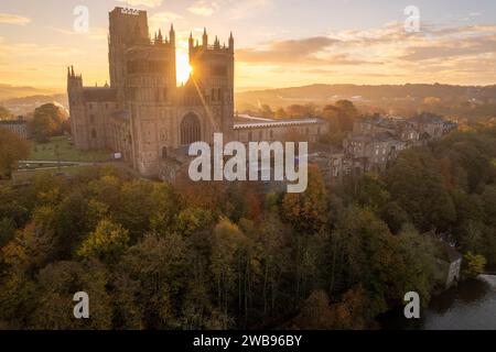 An einem atemberaubenden Herbstmorgen geht die Sonne zwischen den beiden Türmen der Kathedrale von Durham auf. Drohnenaufnahme Stockfoto