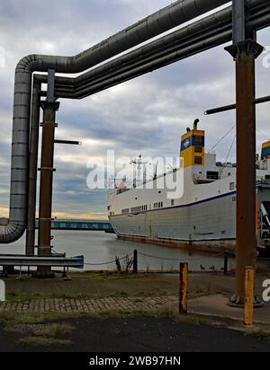 Das „Celestine“ Roll-on-Roll-off-Frachtschiff, eingerahmt von modernen Hochdruckdampfrohren und den alten Pflastersteinen am Hafen von Brocklebank in Liverpool Stockfoto
