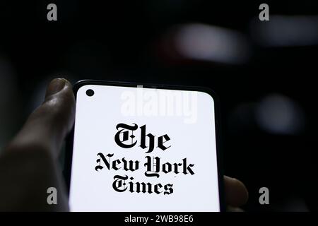 Dhaka, Bangladesch – 09. Januar 2024: Hände halten ein Smartphone mit dem Logo der New York Times auf dem Bildschirm. Die New York Times ist eine US-amerikanische Zeitung. Stockfoto