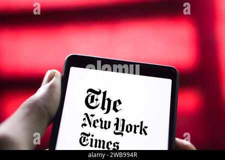 Dhaka, Bangladesch – 09. Januar 2024: Hände halten ein Smartphone mit dem Logo der New York Times auf dem Bildschirm. Die New York Times ist eine US-amerikanische Zeitung. Stockfoto