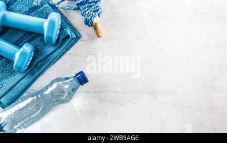 Set aus Sportausrüstung, Kurzhanteln, Sprungseil, Handtuch und Wasserflasche. Sport und gesundes Lifestyle-Konzept. Stockfoto