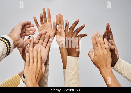 Beschnittene Aufnahme der afroamerikanischen Gemeinschaft, die Hände auf grauem Hintergrund ausstreckt, Juneteenth Stockfoto