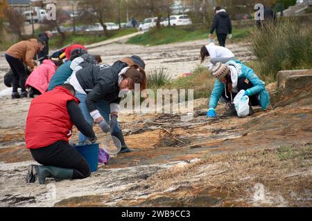 Zahlreiche Freiwillige gingen an die Strände von Galicien, um Plastikgranulat zu sammeln, das auf ein Boot gefallen war, mit einfachen Werkzeugen wie Trichtern, Sieben, Stockfoto