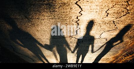 Schatten-Silhouette bei Sonnenuntergang. Jungvermählte und Ehrenmädchen und bester Mann. Friends Forever Konzept auf der Straße. Stockfoto