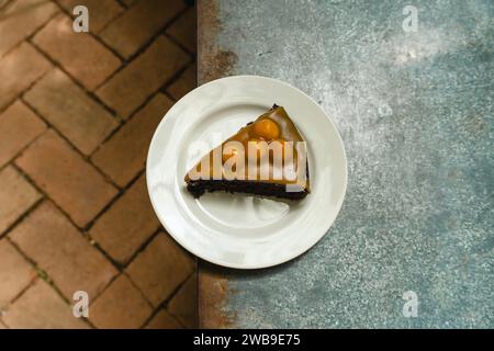 Karamell-Macadamia-Schokoladenkuchen. Nahaufnahme eines kleinen süßen dekorativen Kuchens. Freier Platz für Text. Menü-Café und Café-Bar. Frischer, hausgemachter MacAdam Stockfoto