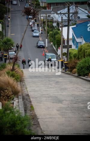 Ein männlicher Straßenradfahrer kämpft um die Baldwin Street, Dunedin, die steilste Straße der Welt. Stockfoto