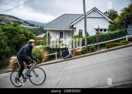 Ein männlicher Straßenradfahrer kämpft um die Baldwin Street, Dunedin, die steilste Straße der Welt. Stockfoto