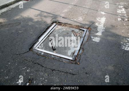 Schutzabdeckung für den Abfluss des Mannlochs auf dem gepflasterten Boden. Öffnung für Wasserabsorptionskanal. Stockfoto